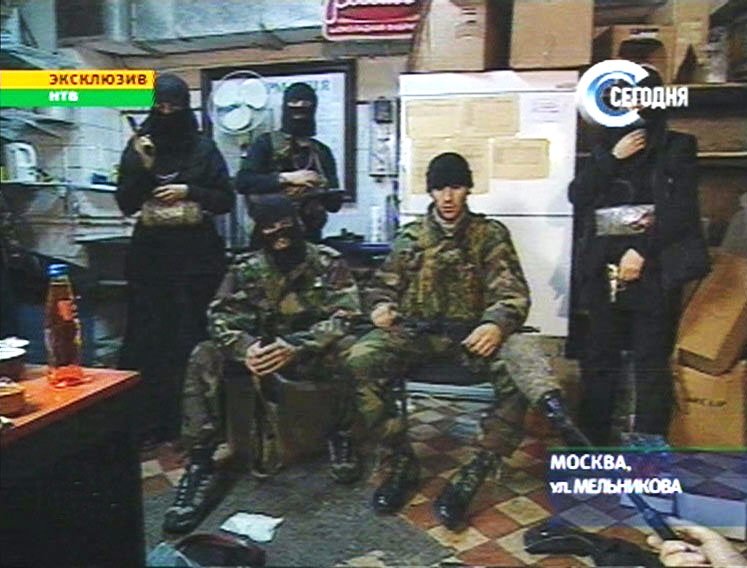25 октября. Мовсар Бараев (в центре) возглавляющий группу террористов, которая захватила заложников в «Норд-осте». Снимок сделан с экрана телевизора, НТВ
