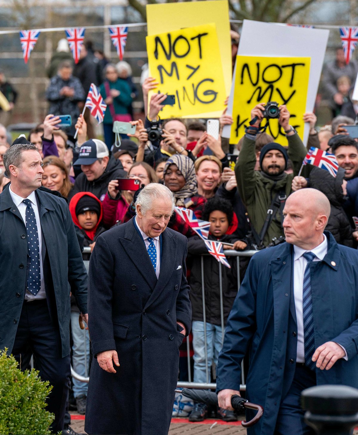 Король Великобритании Карл III проходит мимо демонстрантов, которые держат плакаты с надписью «Не мой король». 16 февраля 2023 года. Фото: ARTHUR EDWARDS / AFP / East News